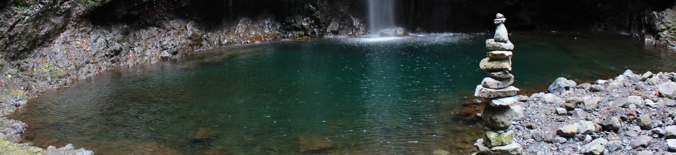 Levada waterfall with a small stone cairn at Caldeirão Verde
